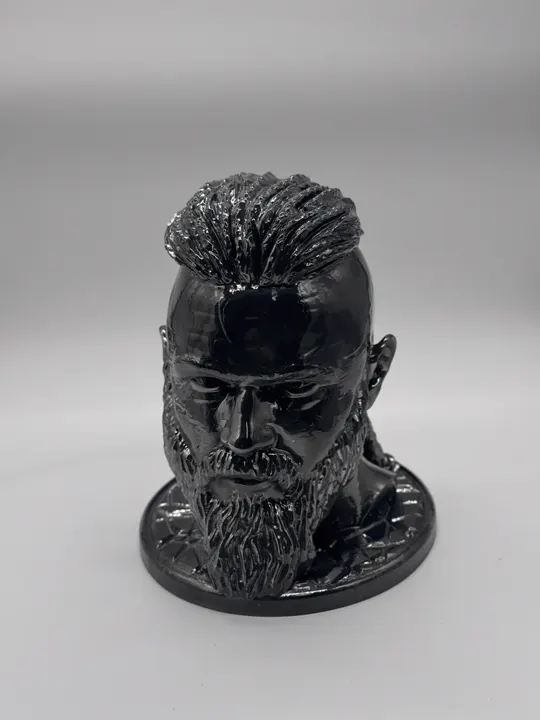 Buste d'homme barbu imprimé en 3D, finition noir brillant, sur un socle rond