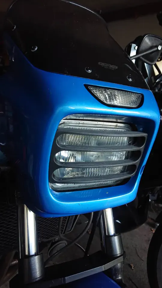 Grille de phare imprimée en 3D, peinte en bleu, montée sur l'avant d'une moto